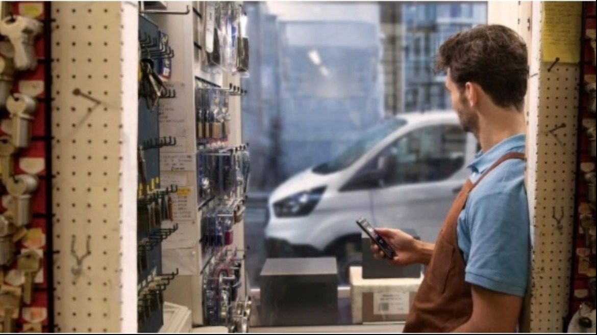Service person in shop checking phone and looking out of window