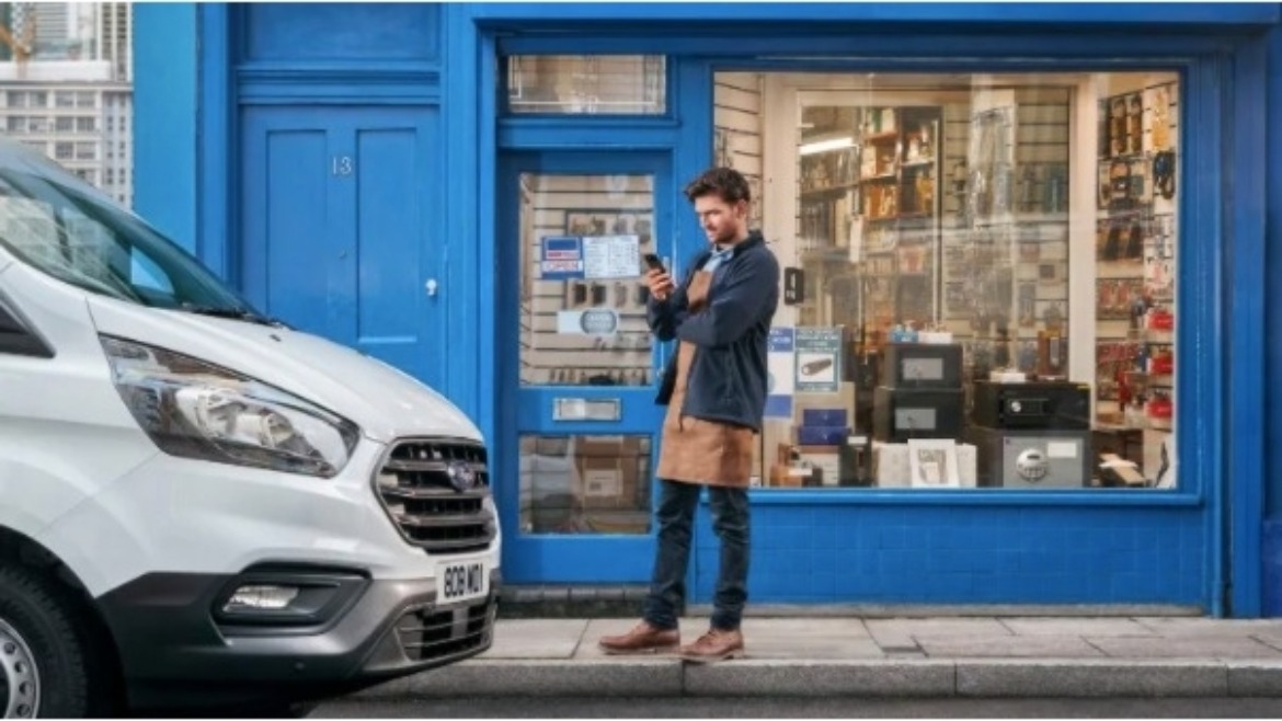 Person in front of shop in phone with a parked Ford van