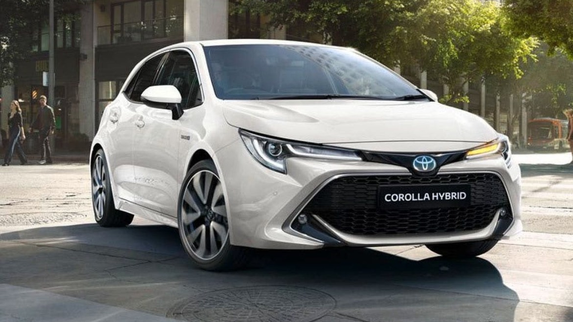 Toyota Corolla Hybrid indicating in a town