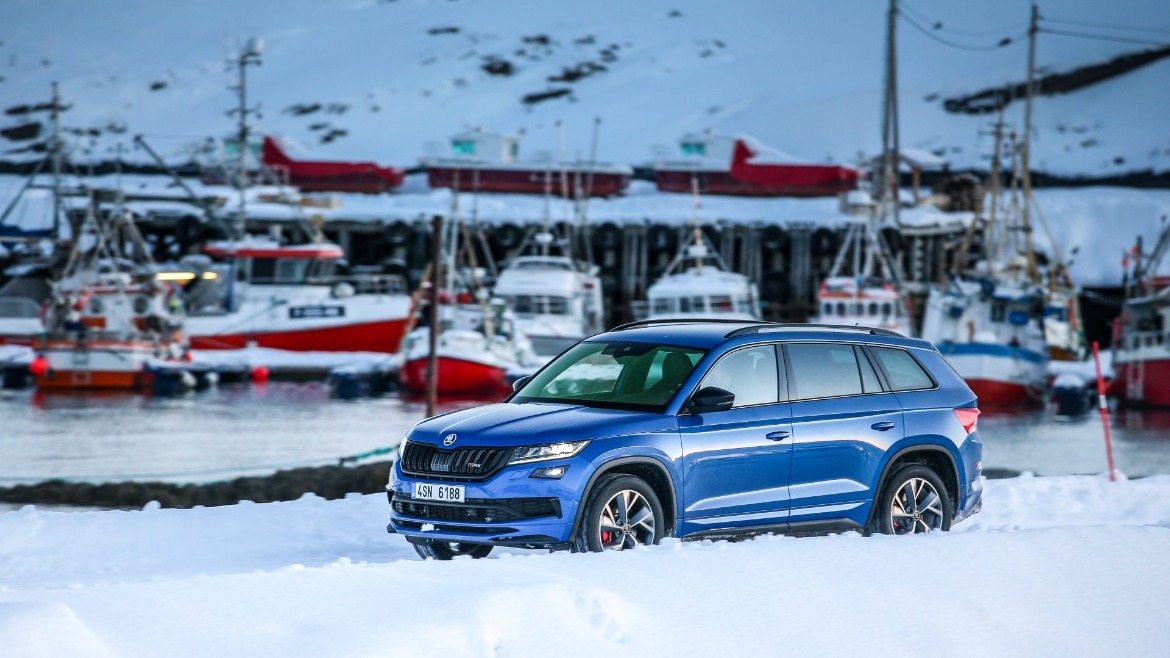 SKODA Kodiaq RS in the snow next to.a lake with boats